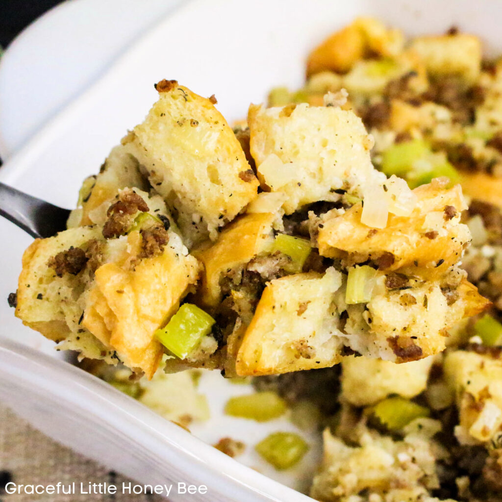 Aerial view of Sage and Sausage Stuffing in a white baking dish with a spoon inserted.
