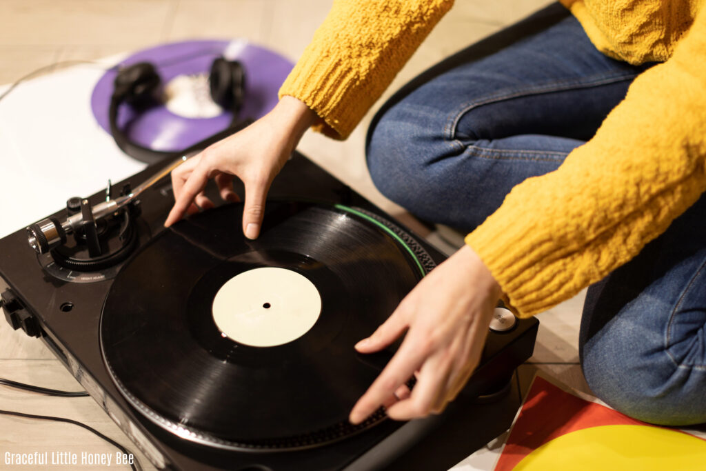 Woman putting record on player.