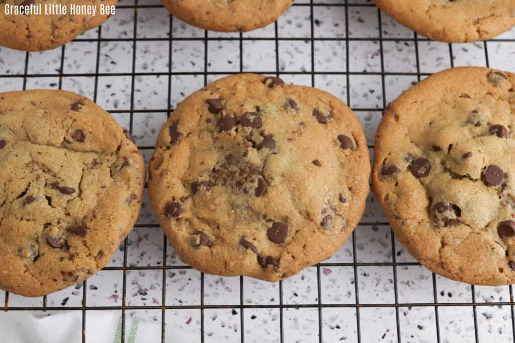 Close up of a cooling rack with Reese's stuffed chocolate chip cookies sitting on top.