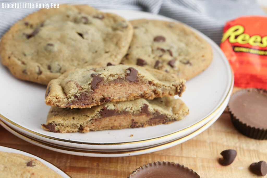 A plate with chocolate chip cookies stuffed with Reese's on a white plate.