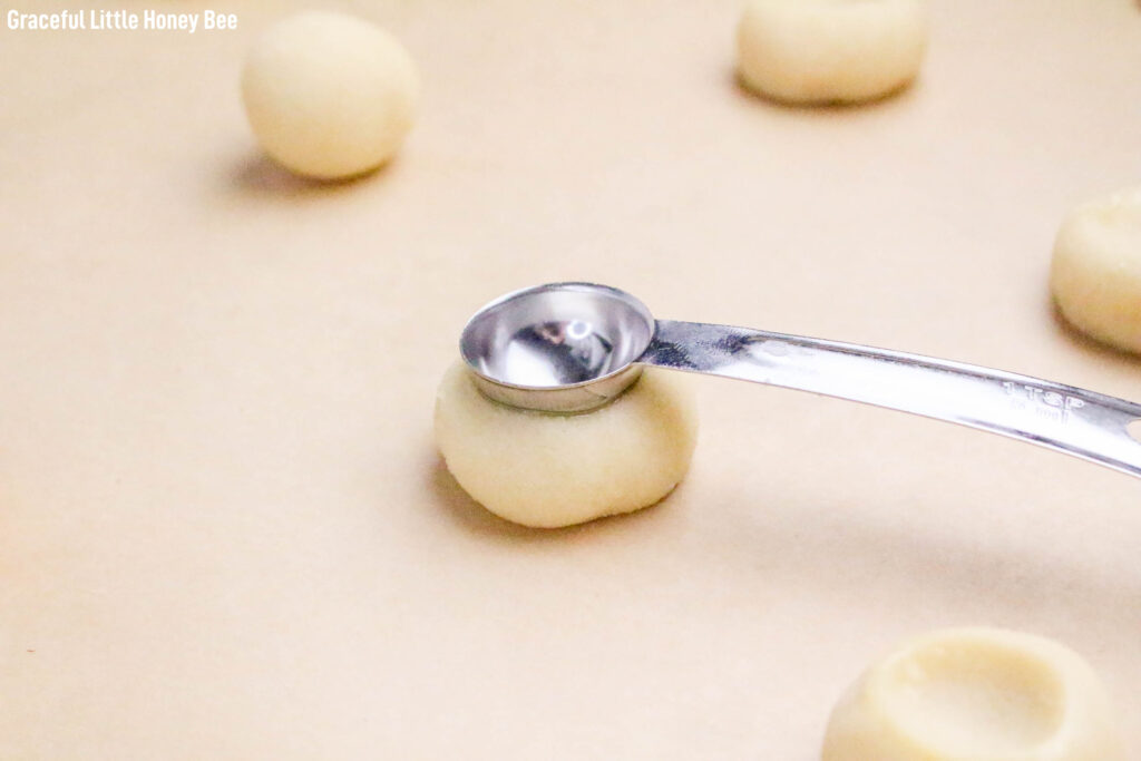 Dough being smushed down by spoon.