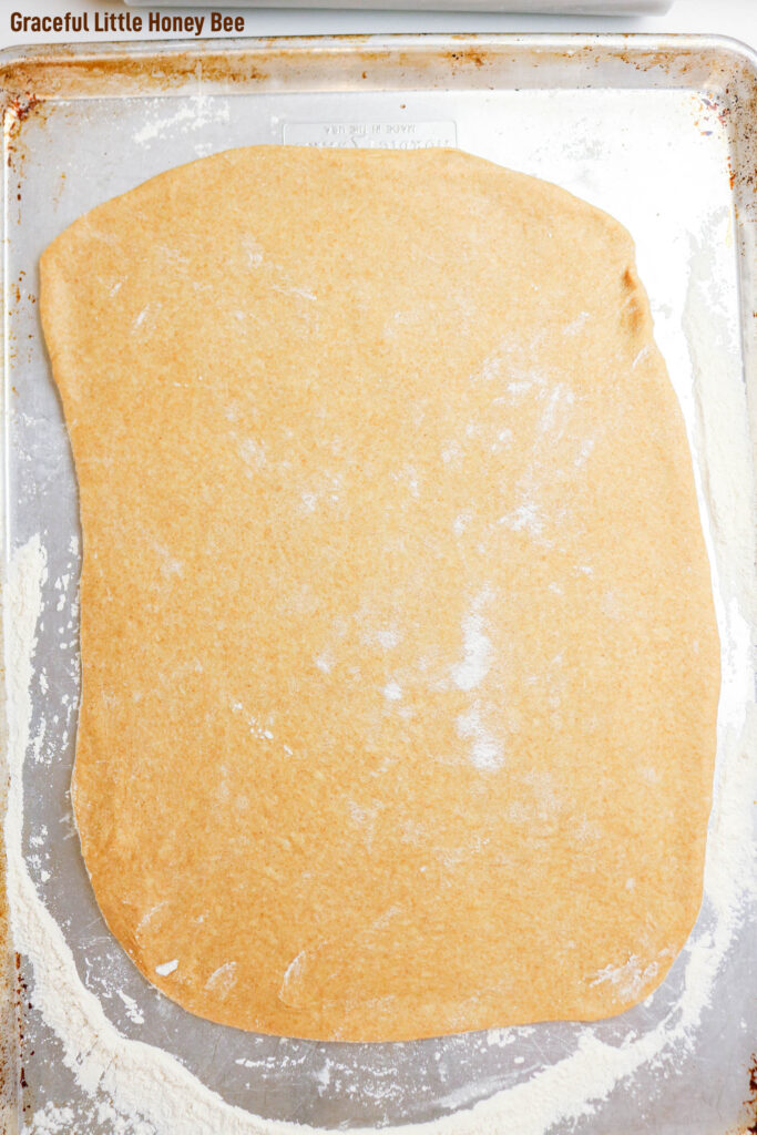 Cinnamon roll dough rolled out in a rectangle.