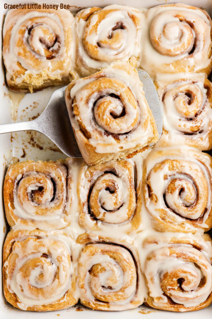 Close up view of a pan of freshly baked and iced cinnamon rolls.
