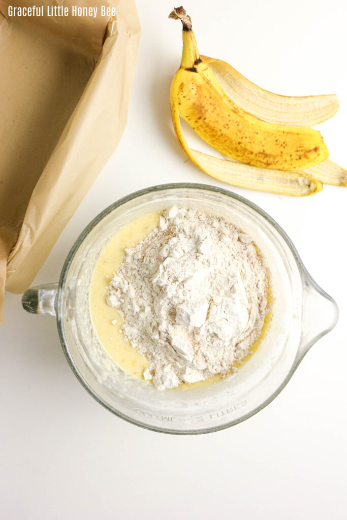 Mixing bowl with mixed wet ingredients and dry ingredients sitting on top.