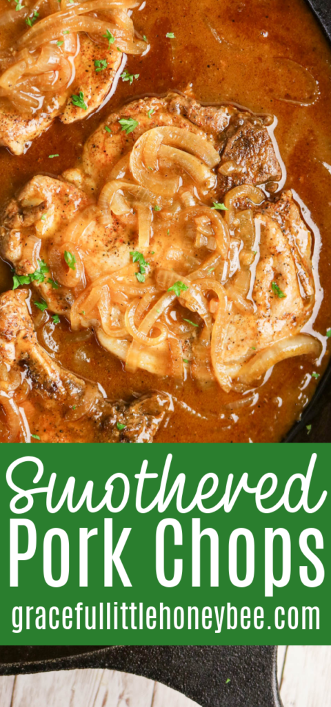 A close up view of a smothered pork chop in a cast iron pan with onion gravy.