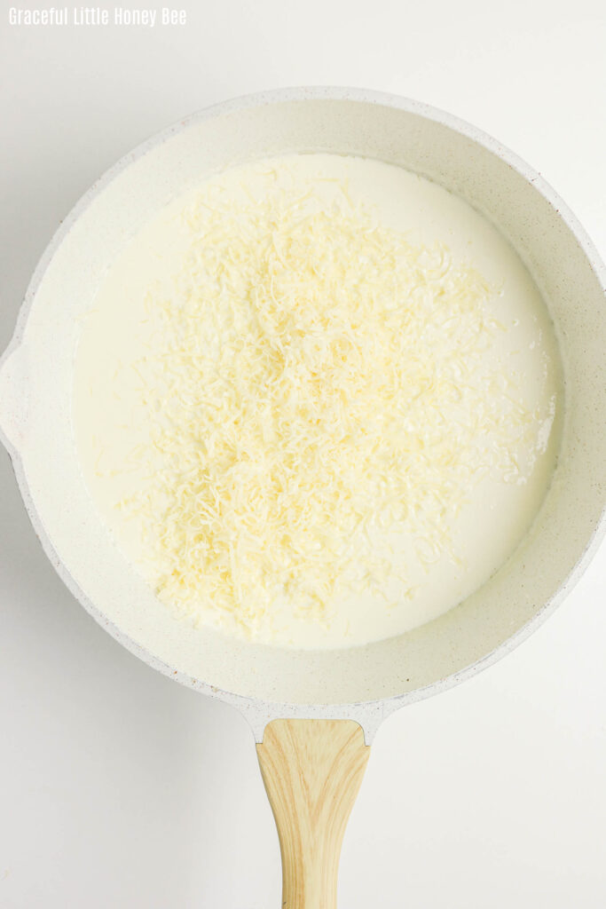 Creamy sauce topped with Parmesan cheese in a pot.