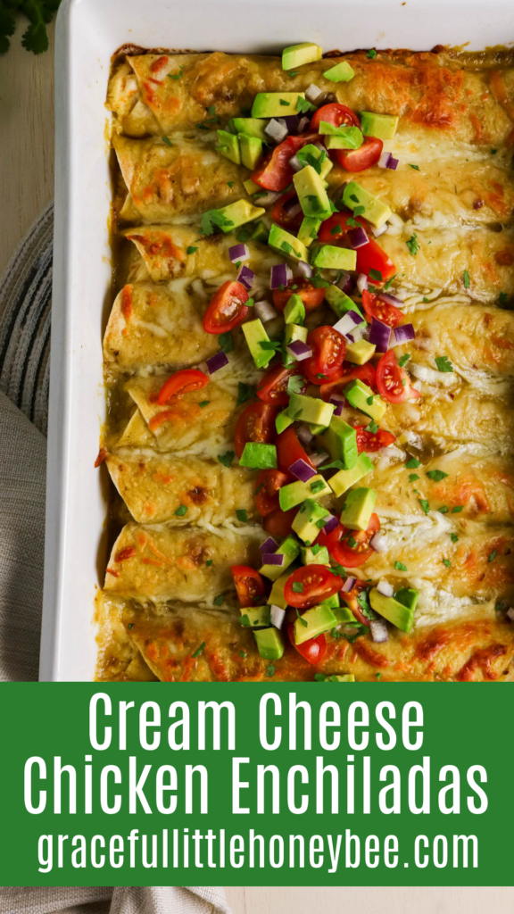 Top view of pan of chicken enchiladas topped with avocado and diced tomatoes. 